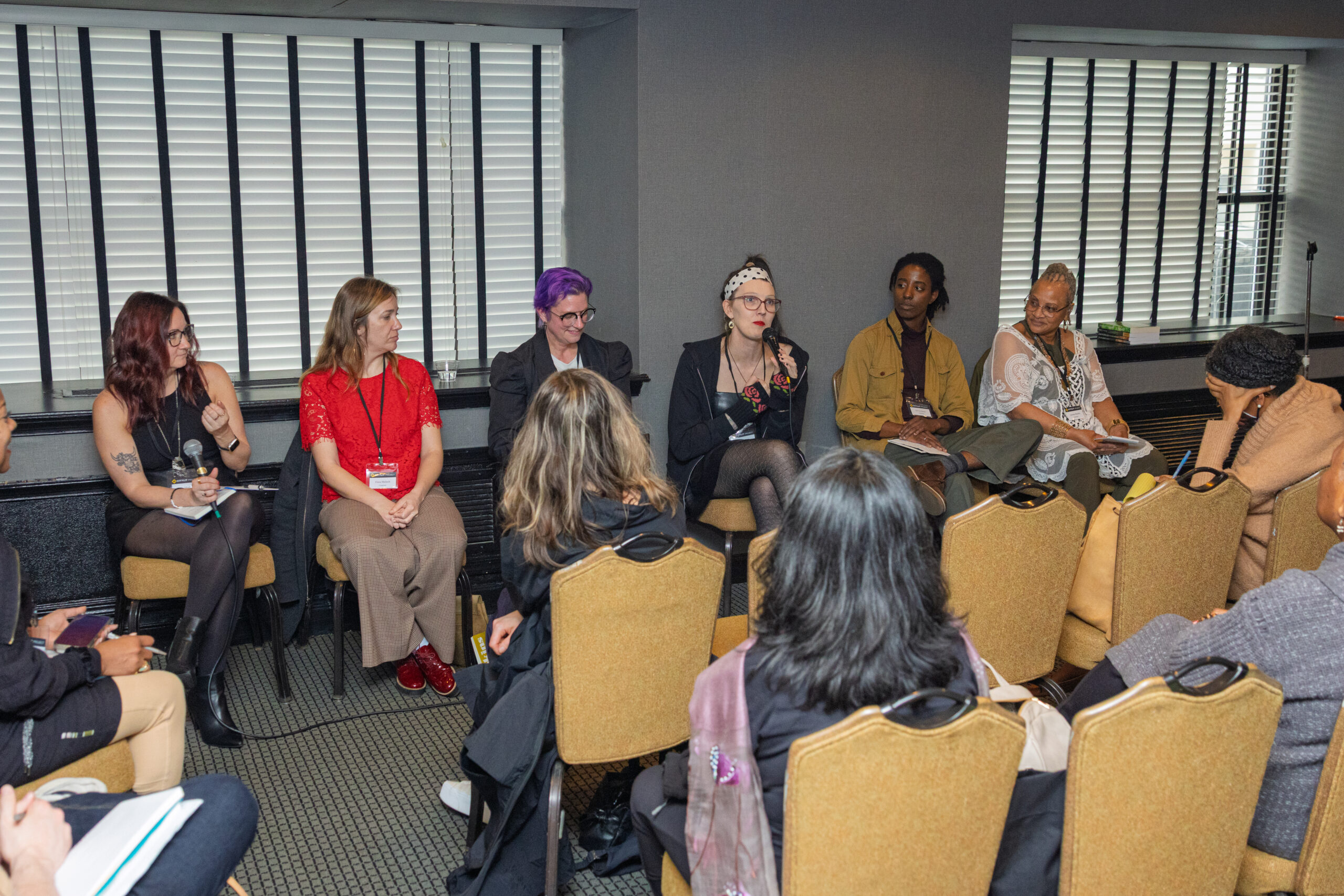 Annie Marhefka, Dora Malech, Sarah Daniels, Casey Plett, Sylvia Jones, and J. Hawki sit in a row in the front of a room.